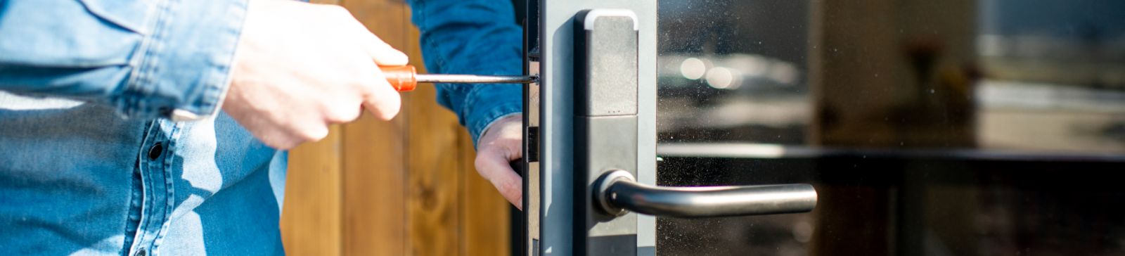 Male locksmith pulling out broken key stuck inside a lock