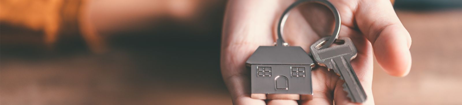 female hand holding a house key