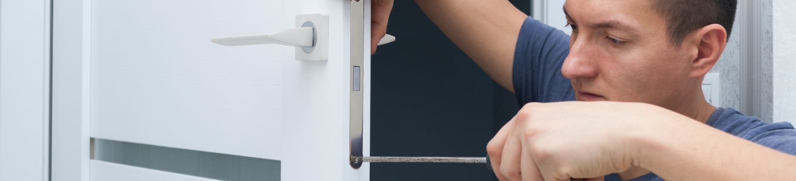 Male locksmith installing a new lock